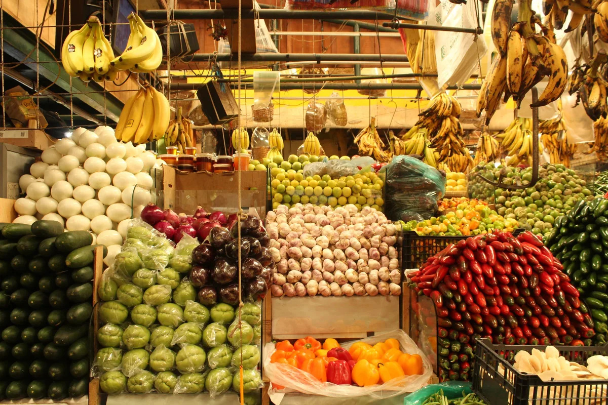 Puesto de mercado con la fruta y la verdura acomodadas por tipo, cada cosa en su lugar